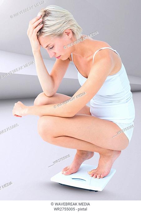Sad woman on weighing scales against minimal background