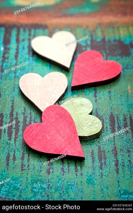 Closeup of different colored wooden hearts on a table