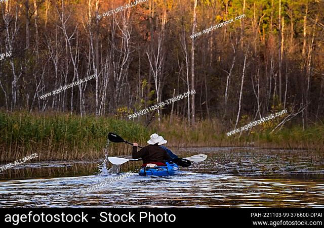 27 October 2022, Brandenburg, Wendisch Rietz: Two people are kayaking on the Glubig-Melang River in the Dahme-Heideseen Nature Park