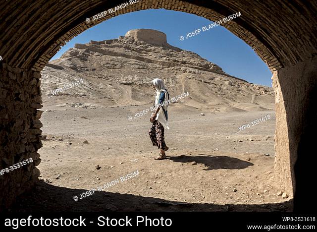 Iranian woman walking through the compound of the towers of silence in Yazd. Iran