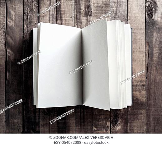 Blank open book, brochure or notebook on wooden table background. Responsive design mockup. Top view. Flat lay
