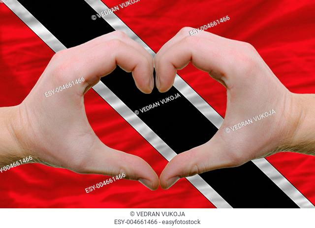 Heart and love gesture showed by hands over flag of trinidad tob