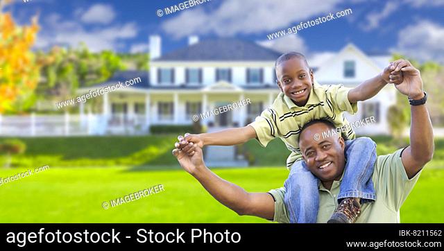 Playful african american father and son in front yard of home