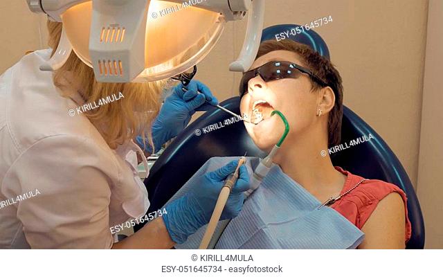 Woman at the dentist clinic office gets dental medical examination and treatment. Odontic and mouth health is important part of modern human life that dentistry...
