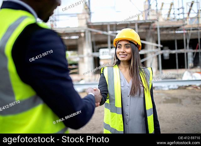 Engineer and forewoman shaking hands at construction site