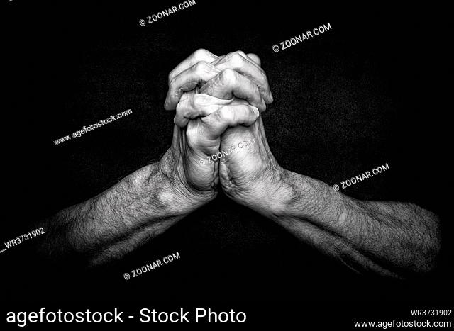 Man's Hands with crossed fingers. This is a classical gesture of a person praying God in the christian religions