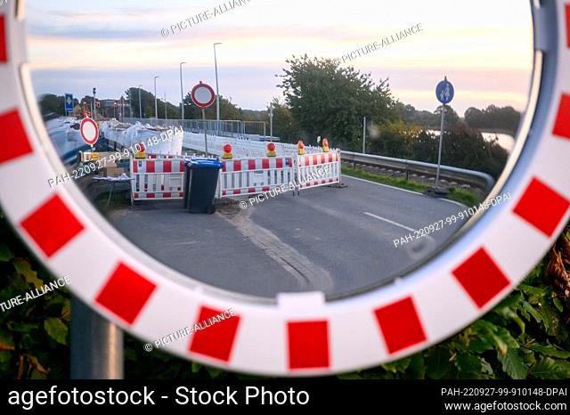 PRODUCTION - 25 September 2022, Schleswig-Holstein, Boren: The construction site barrier on the closed road in front of the Lindaunis bridge is reflected in a...