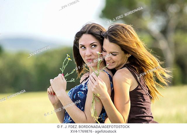 Couple of girls playing and enjoyment whit flowers in the countryside