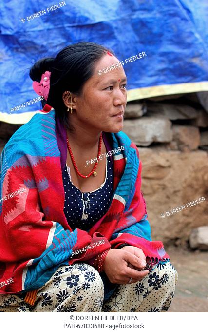 A Nepalese woman named Makha sits in front of the ruins of her house in Suspa, Nepal, 01 April 2016. Many people in rural regions have no funds for the...