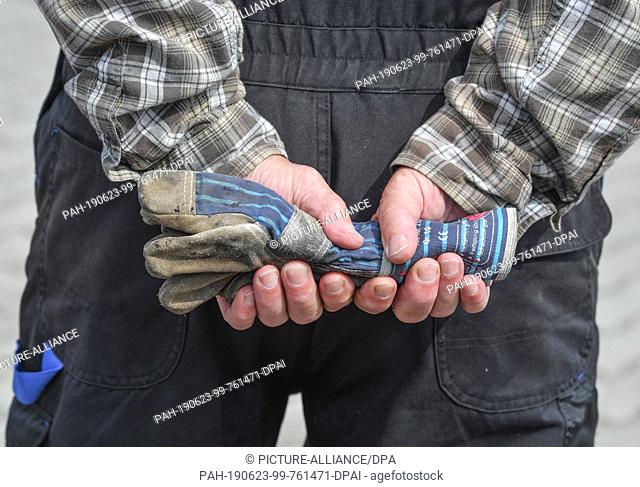 21 June 2019, Brandenburg, Vetschau: A man in work clothes is holding work gloves in his hands. Photo: Patrick Pleul/dpa-Zentralbild/ZB