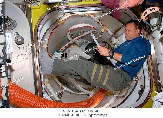 Astronaut Ron Garan, STS-124 mission specialist, goes over a checklist while preparing for the third and final session of extravehicular activity (EVA)...