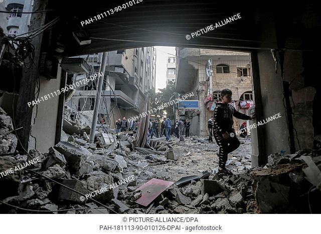 13 November 2018, Palestinian Territories, Gaza: A Palestinian inspects the damage of a destroyed residential building after hitting by Israeli air strikes