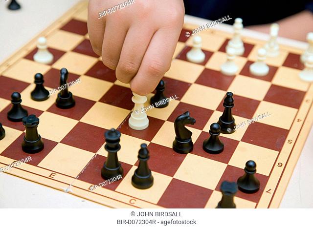 Primary school boy playing a game of chess in an after school club