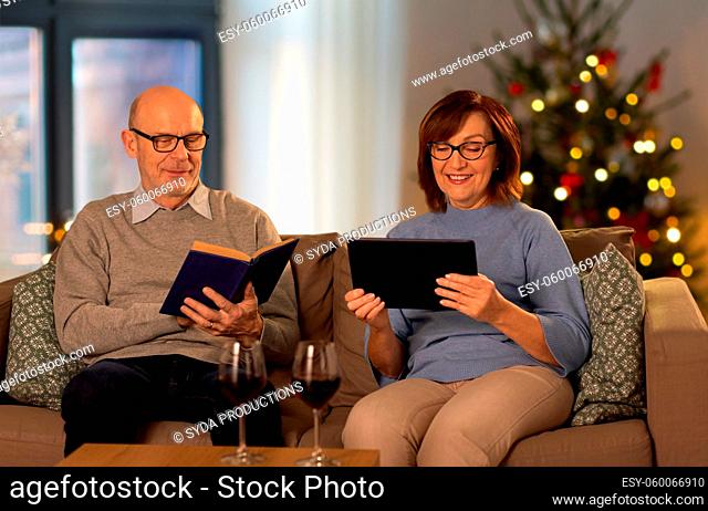 senior couple with book and tablet pc at home
