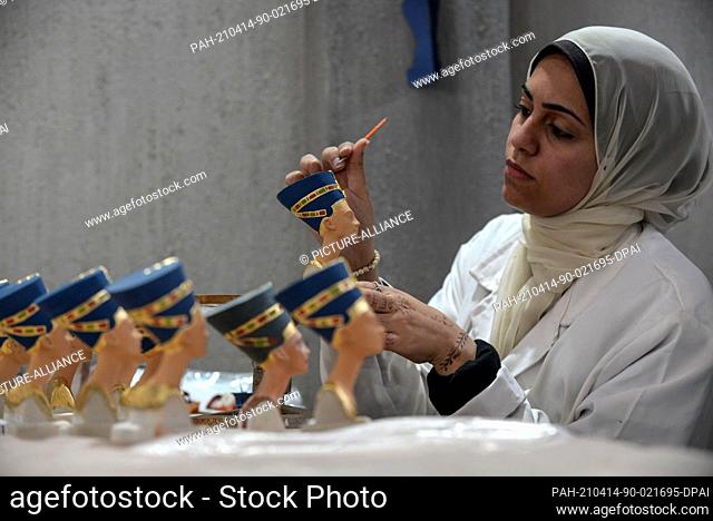 13 April 2021, Egypt, Obour City: A craftswoman works on creating model replicas of the ancient Egyptian Nefertiti Bust, at Konouz factory