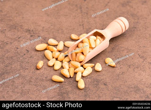 Pine nut seeds on a brown textured stone background, empty copy space