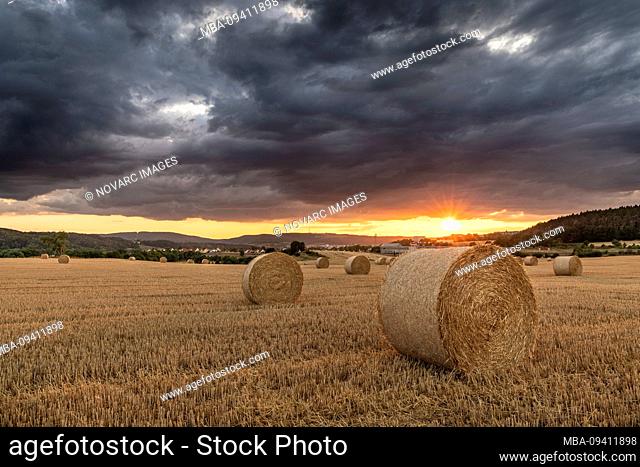 Storm over a stubble field at sunset, Thuringia, Germany