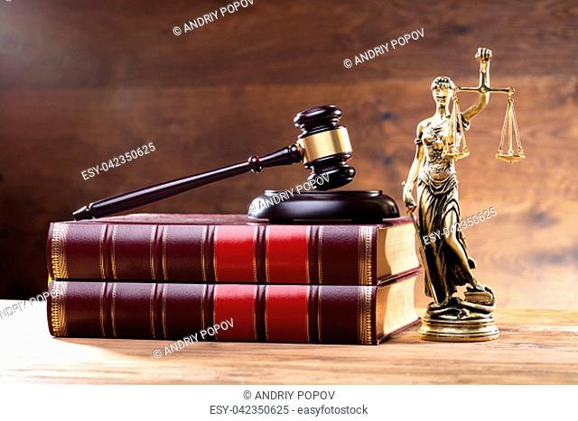 Close-up Of Golden Lady Justice Near Wooden Gavel Over Law Book
