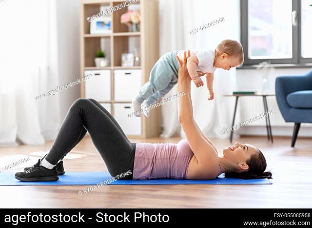 happy mother with little baby exercising at home