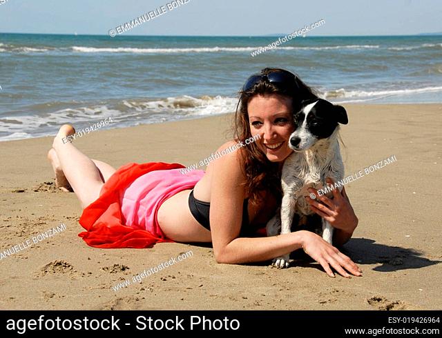 happy woman on the beach with her dog