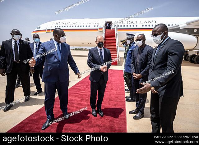 22 May 2022, Senegal, Dakar: German Chancellor Olaf Scholz (M r, SPD), is greeted with military honors at the airport by Macky Sall