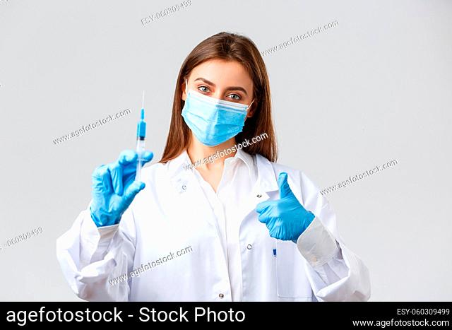 Covid-19, preventing virus, healthcare workers and quarantine concept. Determined young doctor in medical mask and rubber gloves