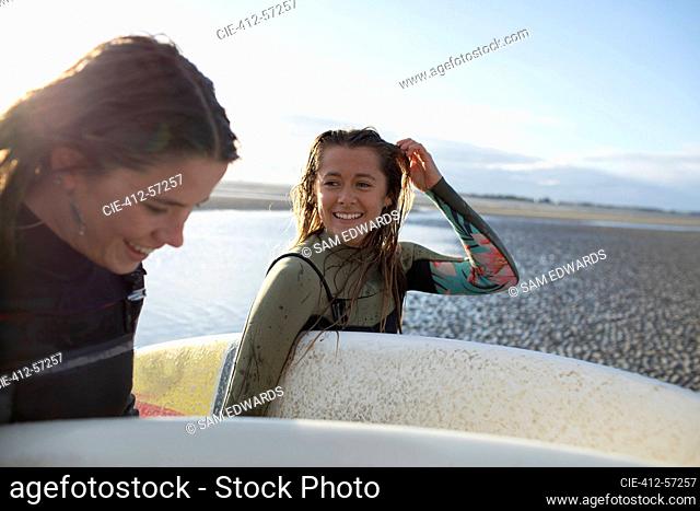 Feliz jóvenes surfistas con tablas de surf en la playa soleada