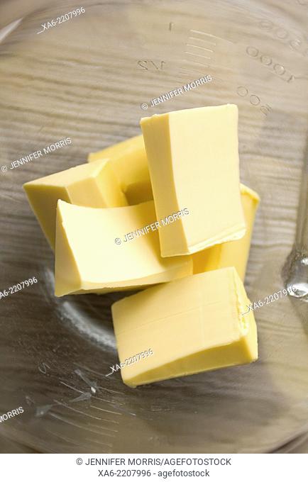 Blocks of butter sit in a glass mixing bowl