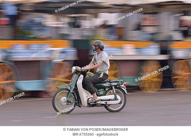 Moped rider at Djemaa el Fna market square, historic center, Marrakesh, Marrakesh-Tensift-El Haouz region, Morocco