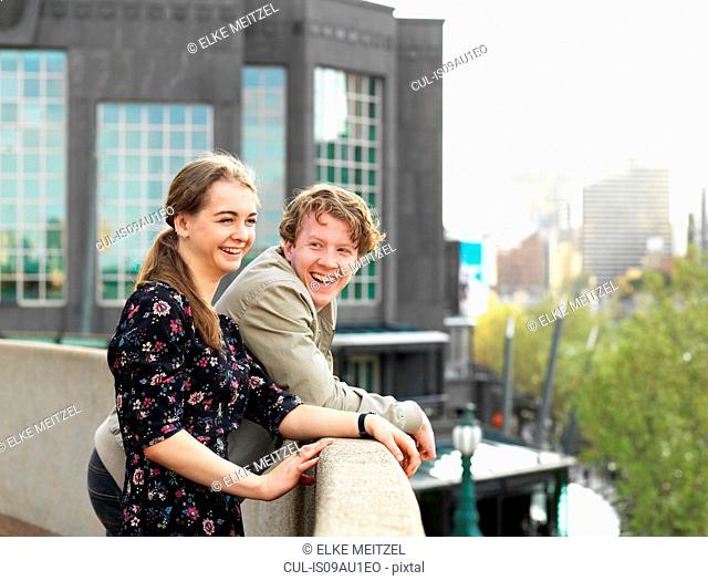 Young couple enjoying view from terrace, Melbourne, Victoria, Australia