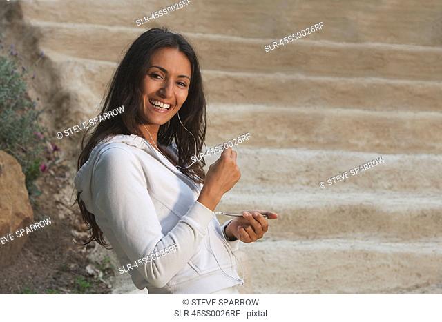 Woman listening to headphones outdoors