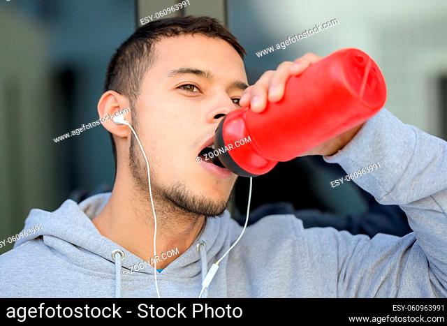 Drinking water sports training fitness young latin man winter running jogging outdoor
