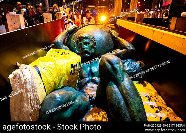 dpatop - 27 September 2023, Hamburg: An Atlas sculpture is unloaded from a container at the main station in the evening. After around 80 years and extensive...