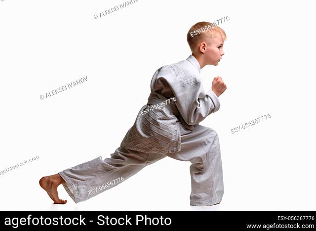 Martial arts student crouches and stretches his legs