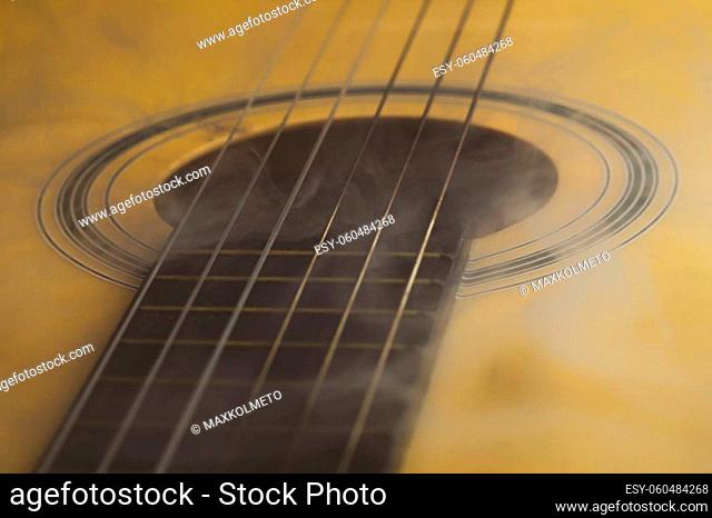 Guitar in smoke close up. acoustic musical instrument. strings on the guitar neck