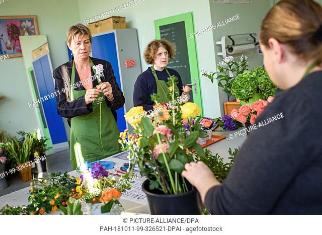 11 October 2018, Berlin: Elke Breitenbach (Die Linke, l), Senator for Integration, Labour and Social Affairs, is preparing a flower arrangement together with...