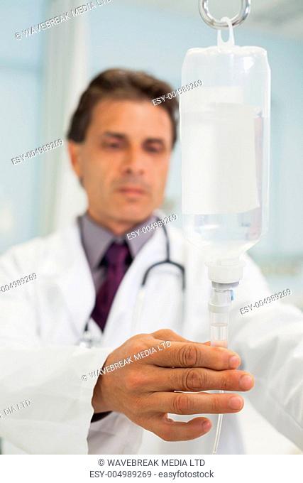Concentrated doctor connecting the phial in hospital