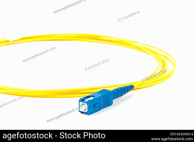 fiber optic single mode small form factor SC patch cord jumper with blue connector isolated on white background