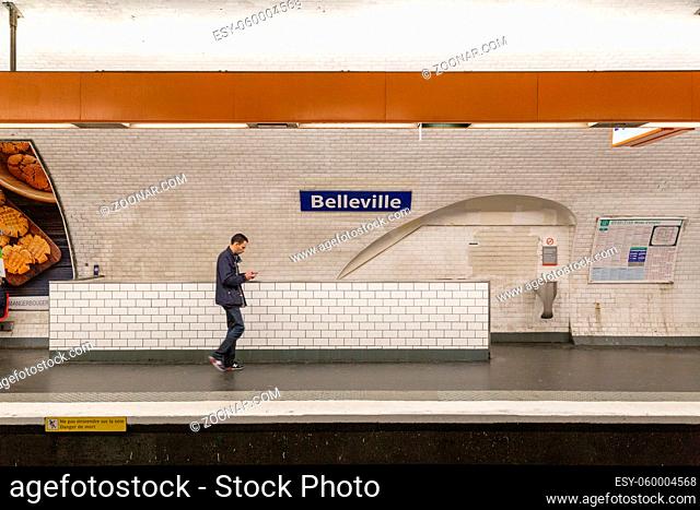 Paris, France - May 12, 2017: A man walking past a sign at Belleville Metro station