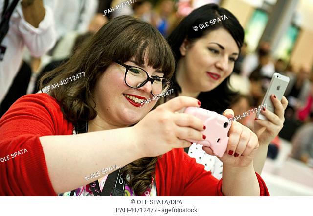 Bloggers take pictures with smartphone and cameras at the curvy is sexy show offsite the Mercedes-Benz Fashion Week in Berlin, Germany, 02 July 2013
