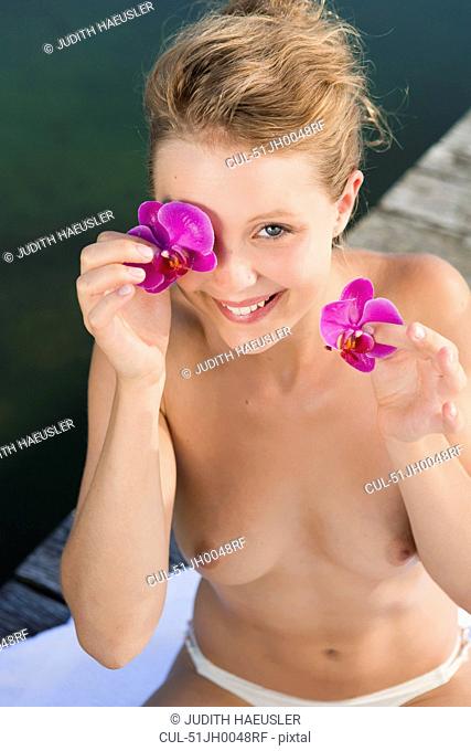 Nude woman playing with flowers