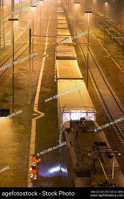 01 December 2022, Saxony, Leipzig: An employee uncouples the locomotive from a freight train at the Leipzig-Wahren transshipment station in the early morning