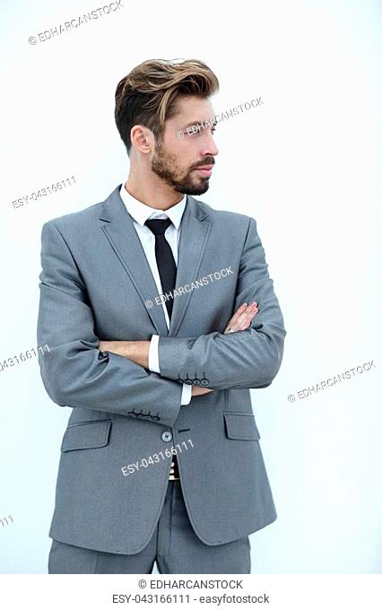 Portrait of a young man standing with arms crossed and looking away. Isolated on white background