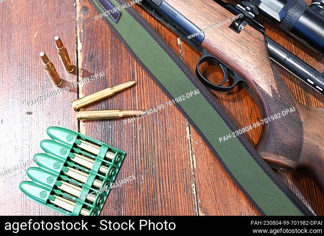 PRODUCTION - 03 August 2023, Baden-Württemberg, Murrhardt: A 30-06 Springfield caliber hunting rifle and ammunition lie on a table