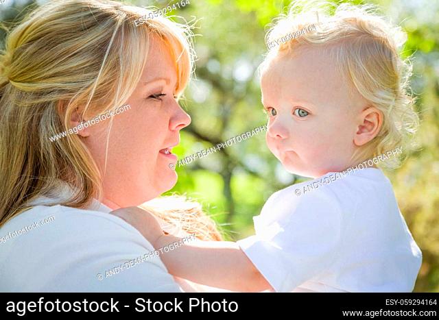 Young Mother Holding Her Adorable Baby Boy in the Park