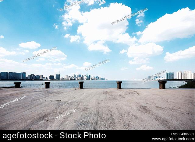 empty concrete floor and cityscape of hangzhou in blue cloud sky