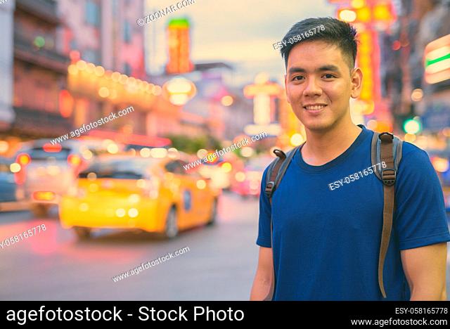Portrait of young handsome Asian tourist man exploring at Chinatown in Bangkok, Thailand