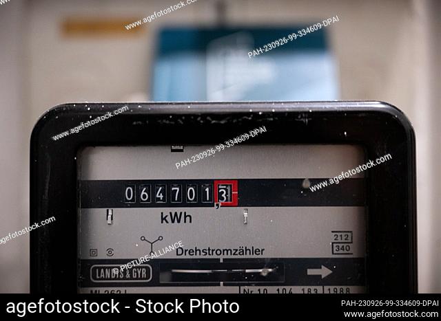 26 September 2023, Berlin: A three-phase meter hangs in an apartment. One year after the German government's ""double whammy"" to ease the burden on customers