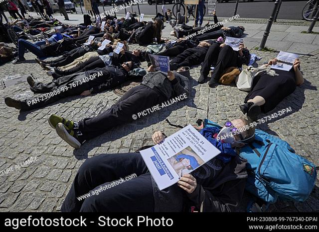 08 August 2023, Berlin: In a reclining demonstration, about fifty demonstrators raise awareness of ME/CFS in front of the Red City Hall