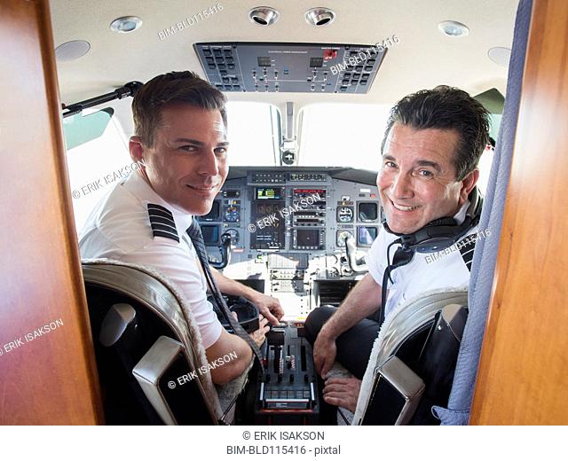 Caucasian pilots in airplane cockpit